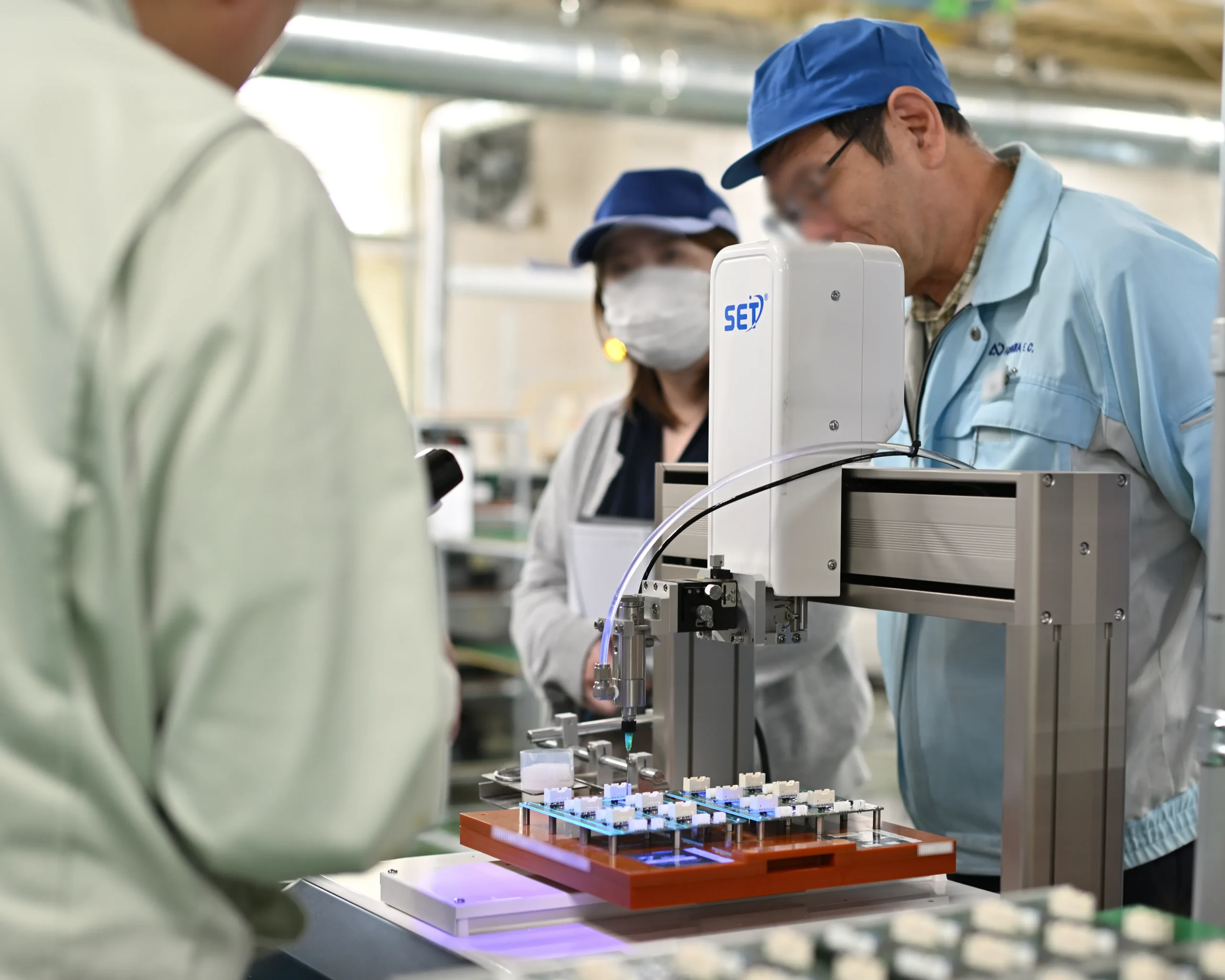 コーティング剤を塗布する自動塗布装置の作業風景。コネクタ端子をはじめ、コーティング剤がかからないようにプログラムを作成