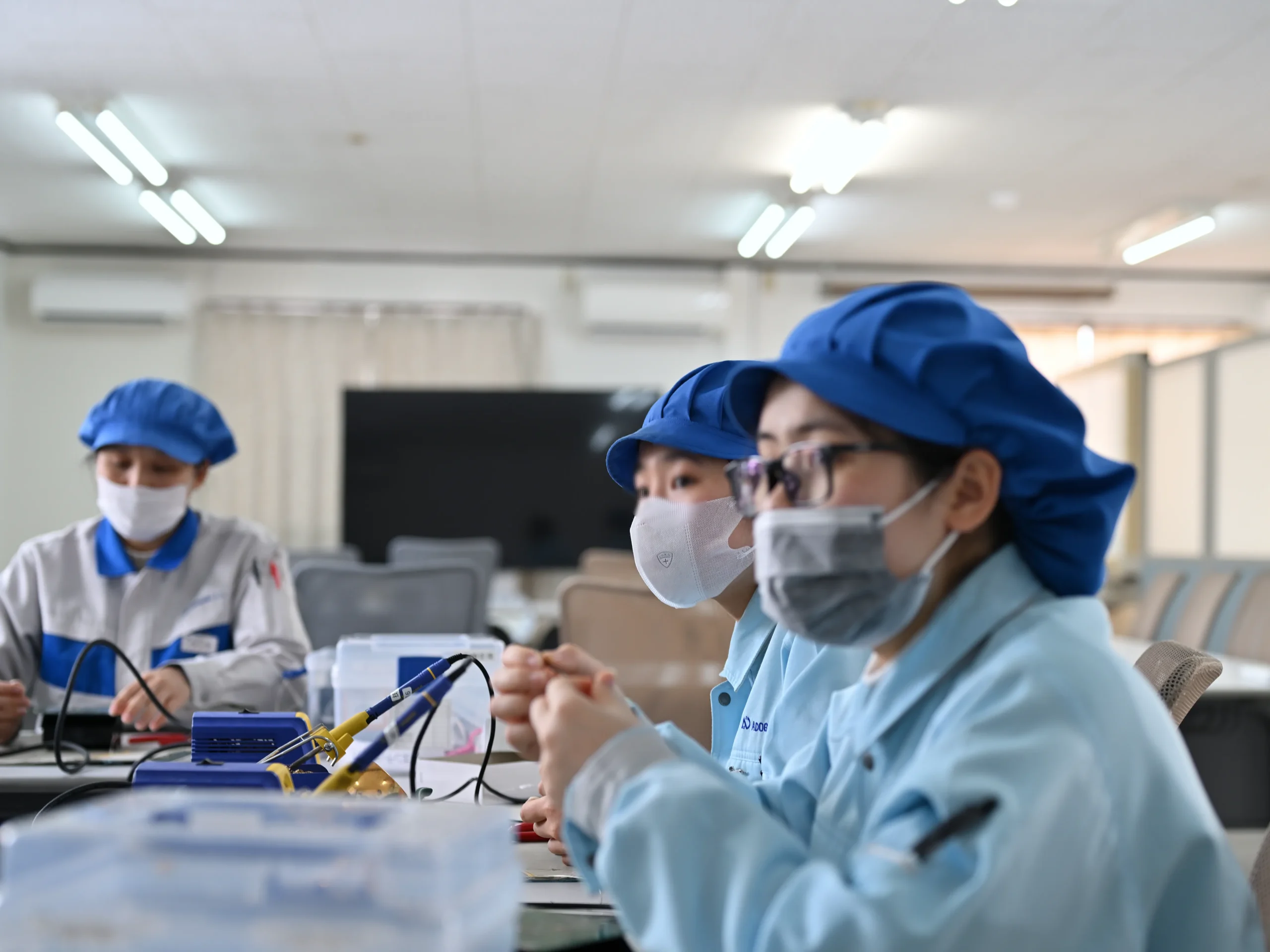 若い従業員が機械を操作し、教育を受けている様子