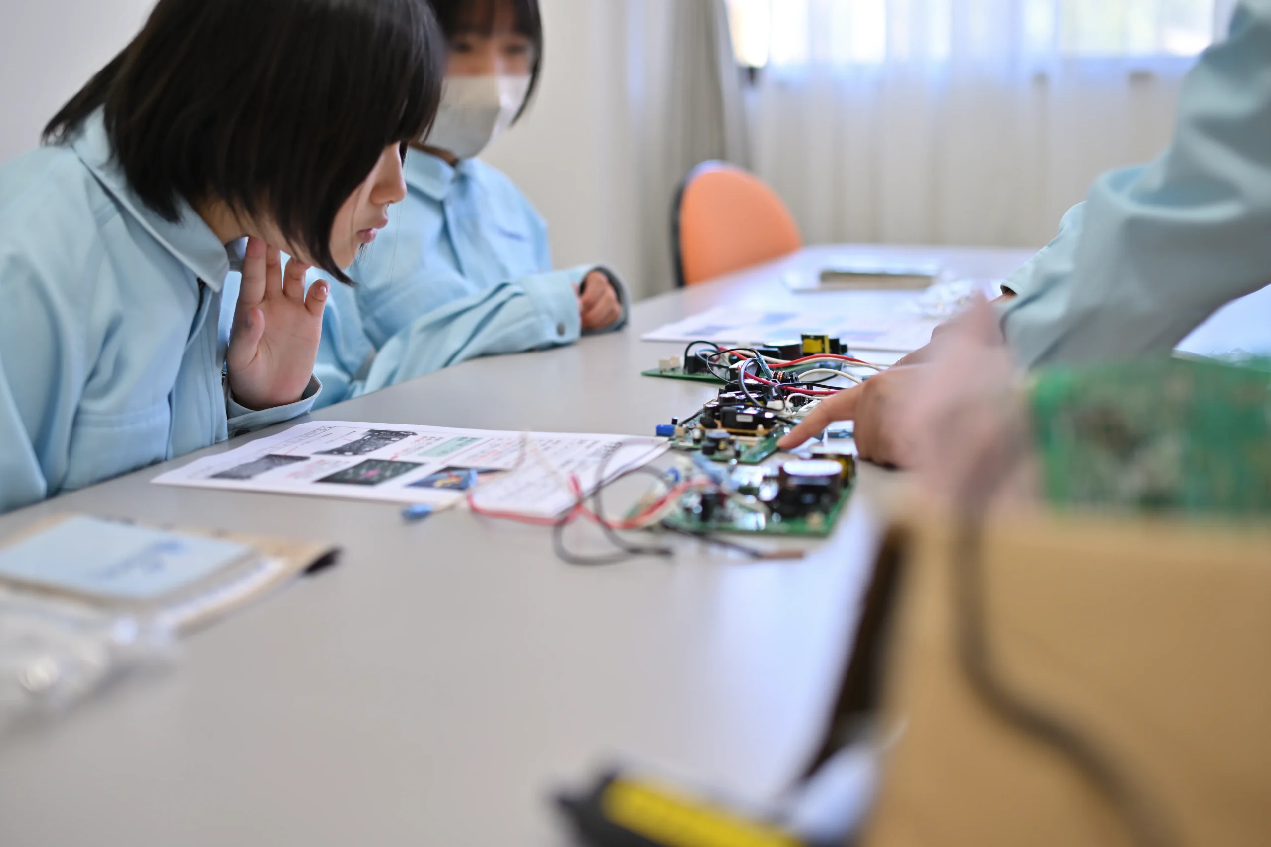 職場体験に来た中学生に説明する従業員