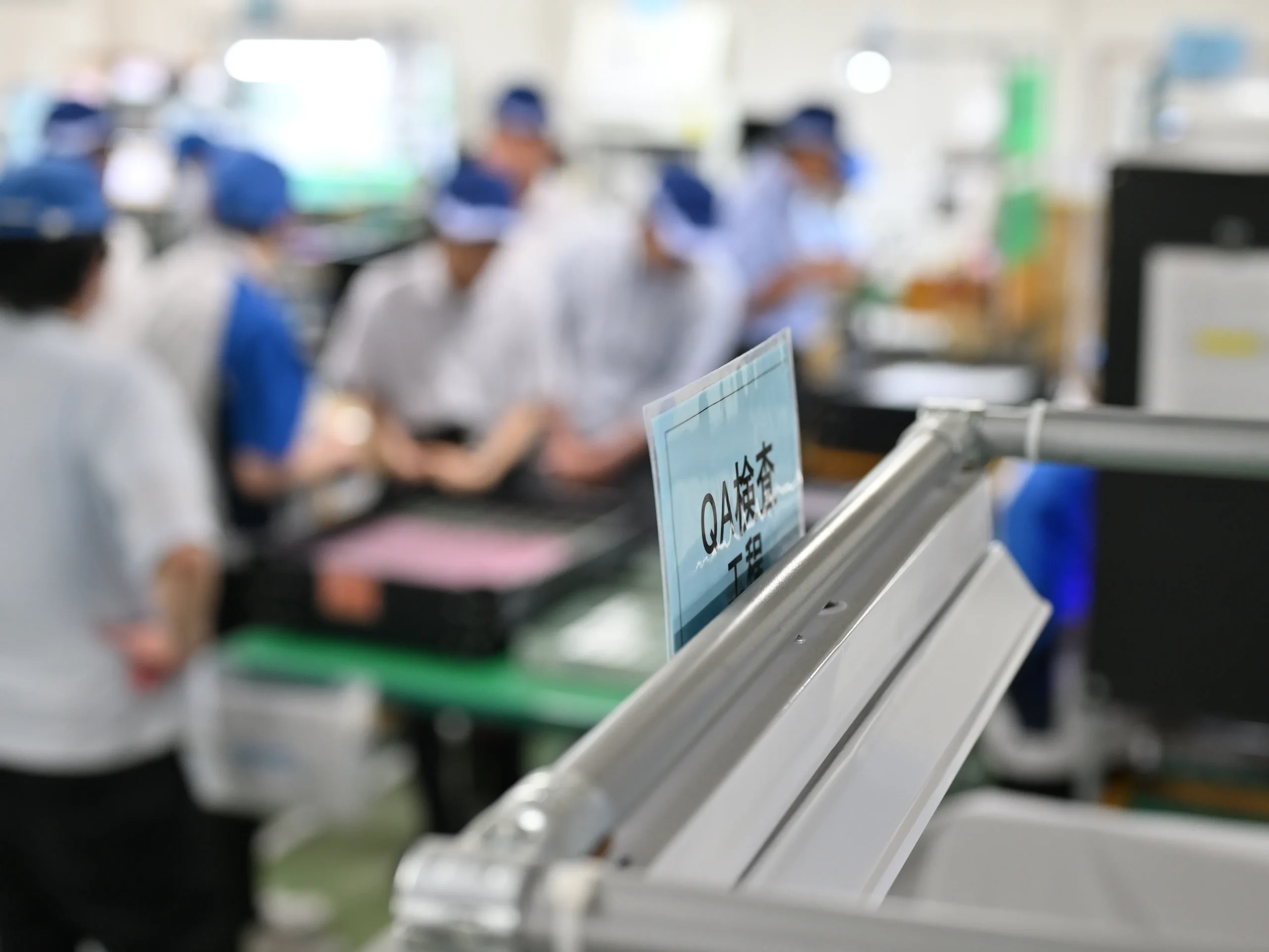 部品を顕微鏡でチェックするなど品質管理を行う従業員