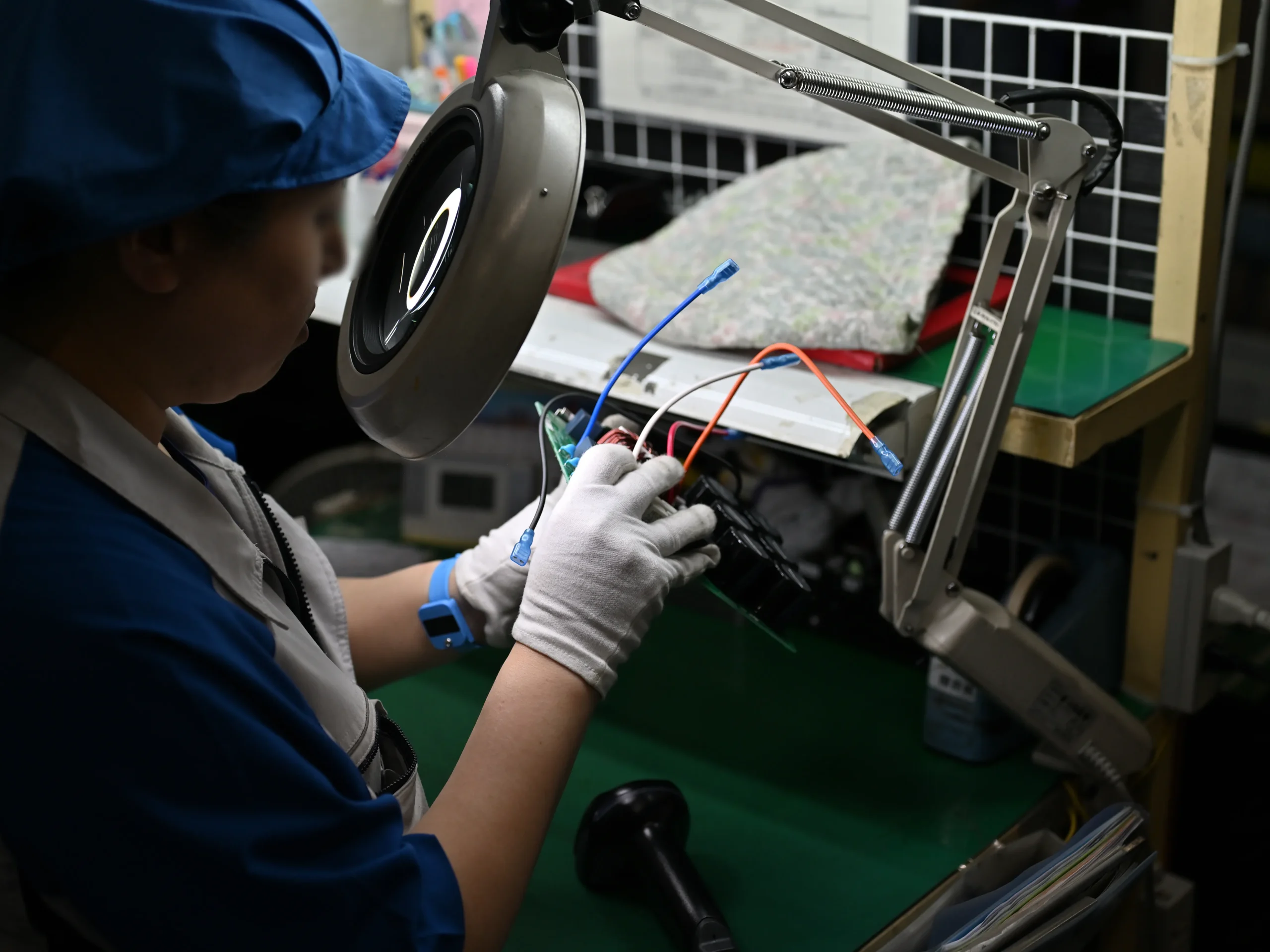 部品を顕微鏡でチェックするなど品質管理を行う従業員