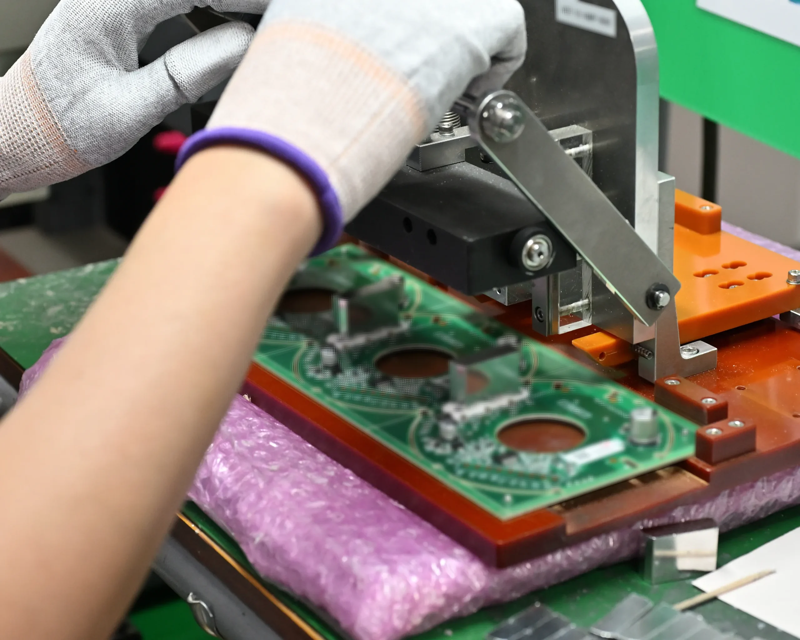 治具で基板を固定し、製造工程の品質を安定化させる作業の様子