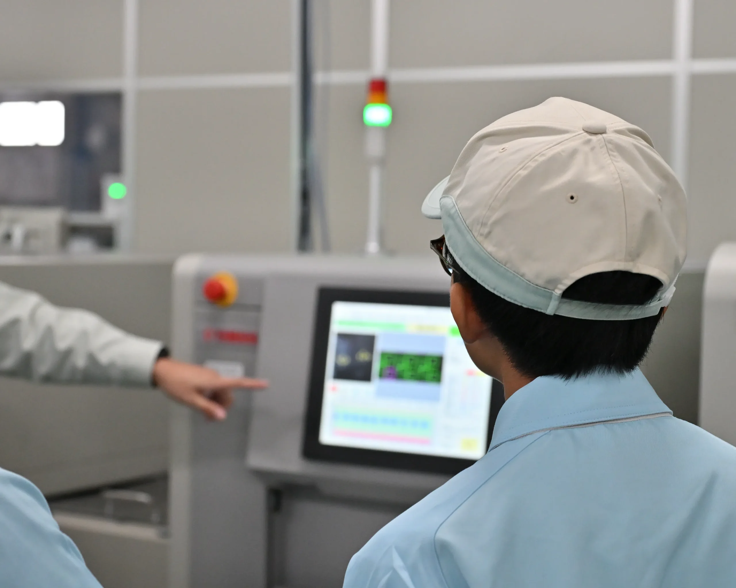 安曇川中学生が、アドガワエレクトロニクスの従業員から、基板実装の説明を受ける様子。