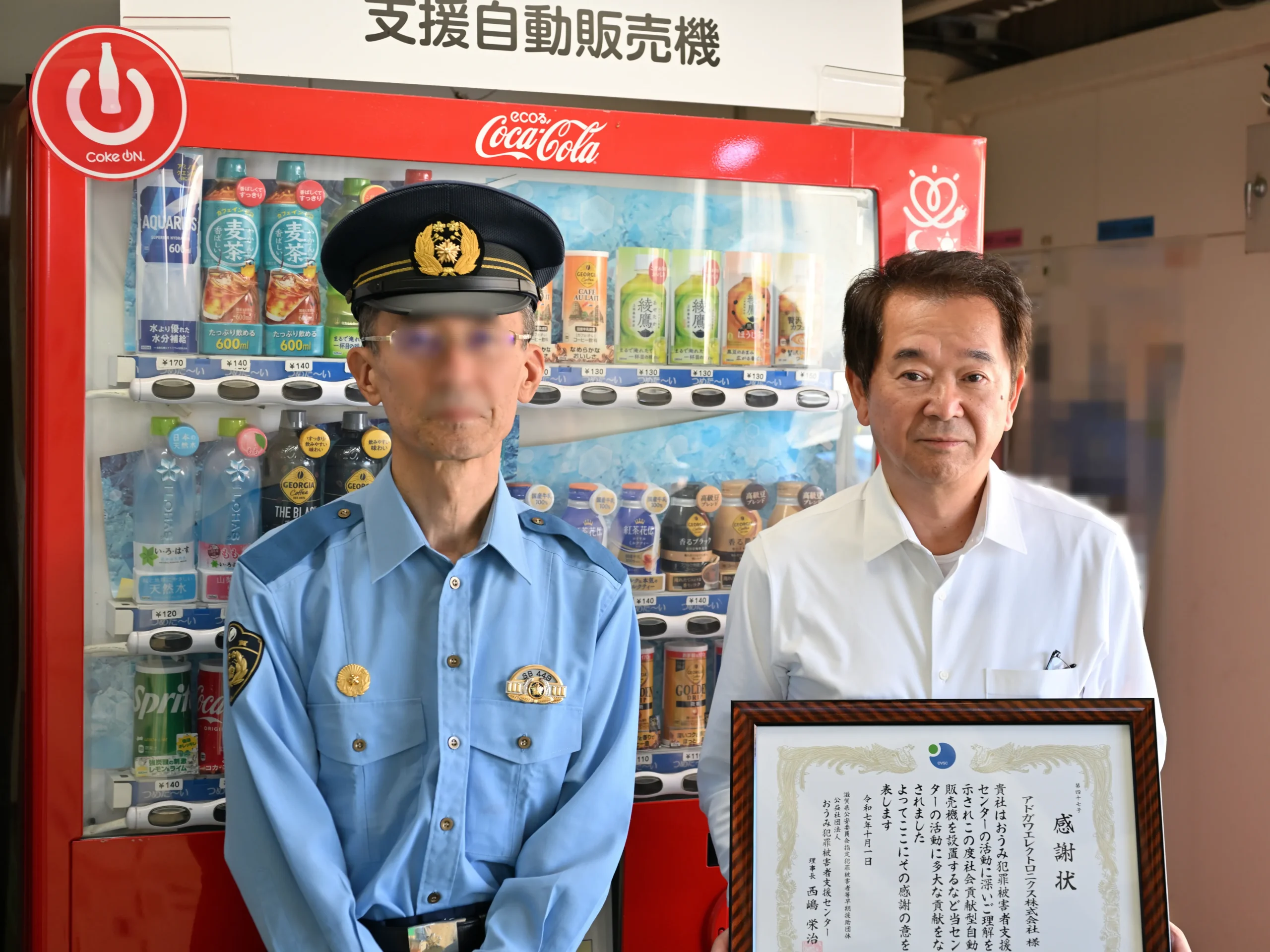 SDGs活動の一環で支援自動販売機を設置し、おうみ犯罪被害者支援センターより感謝状を受け取るアドガワエレクトロニクスの代表