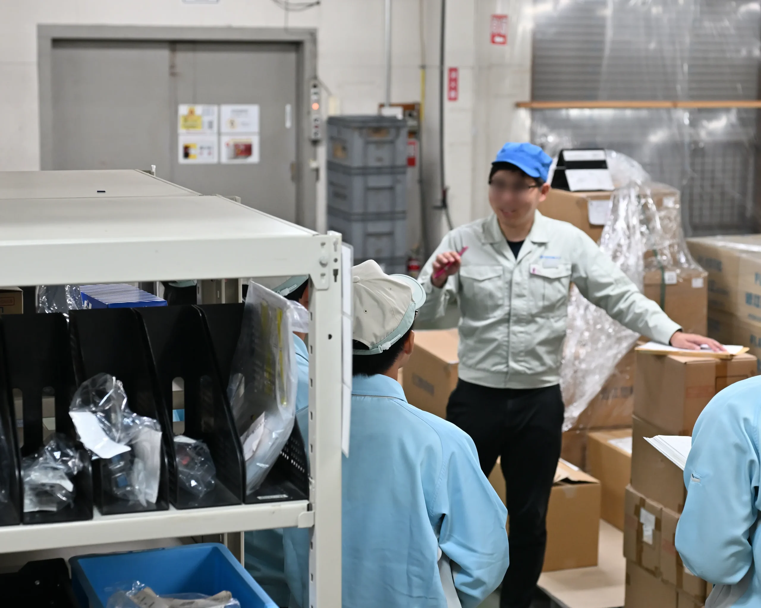 アドガワエレクトロニクスの従業員が、職場体験学習に訪れた安曇川中学生に仕事の内容を紹介する様子。