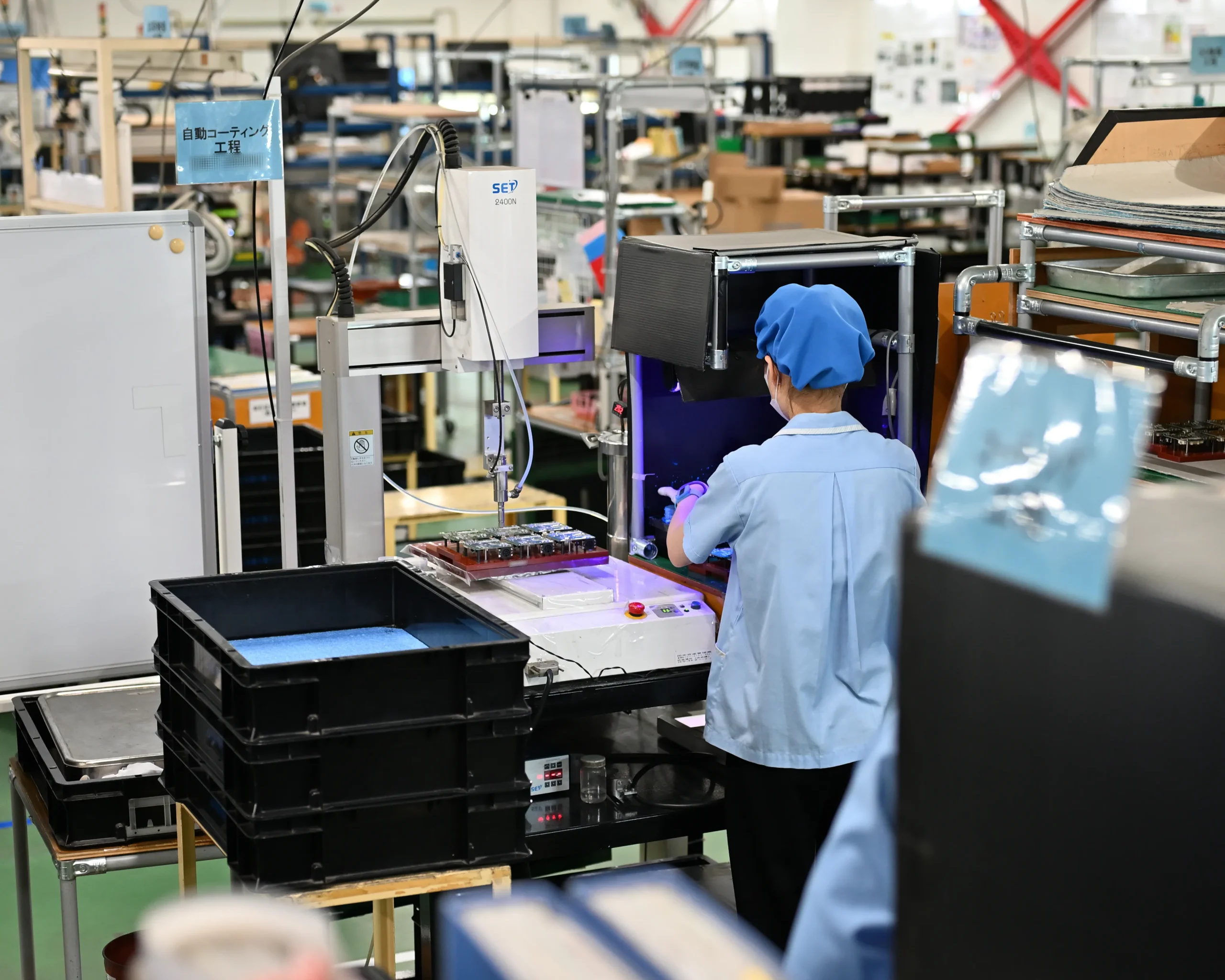 自動コーティング工程で集中して作業する従業員。目標設定と継続的な行動が仕事のやりがいを生み、組織全体の生産性と雰囲気を向上させる。