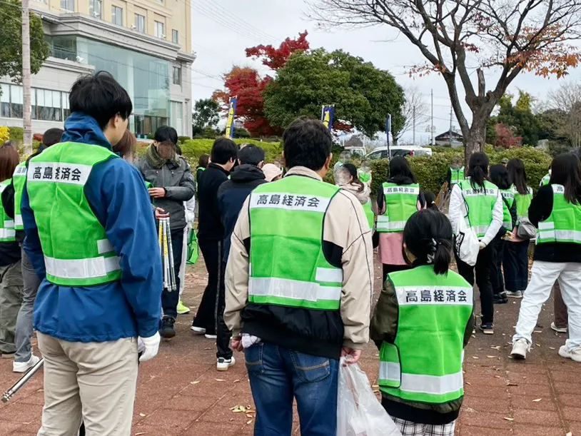 企業と地域住民が琵琶湖湖岸で清掃活動を行う様子。