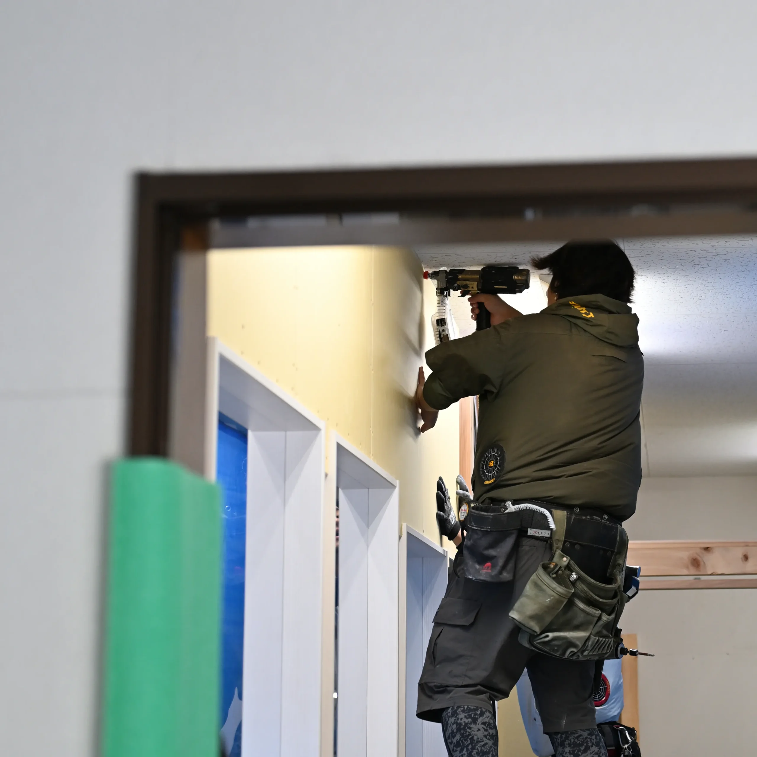 電動工具を使って事務所の改装工事を行う建築作業員の写真。組織のコミュニケーション活性化や生産性向上、スペースの効率化などを目的に、改装工事を経て事務所のフリーアドレス化を推進する