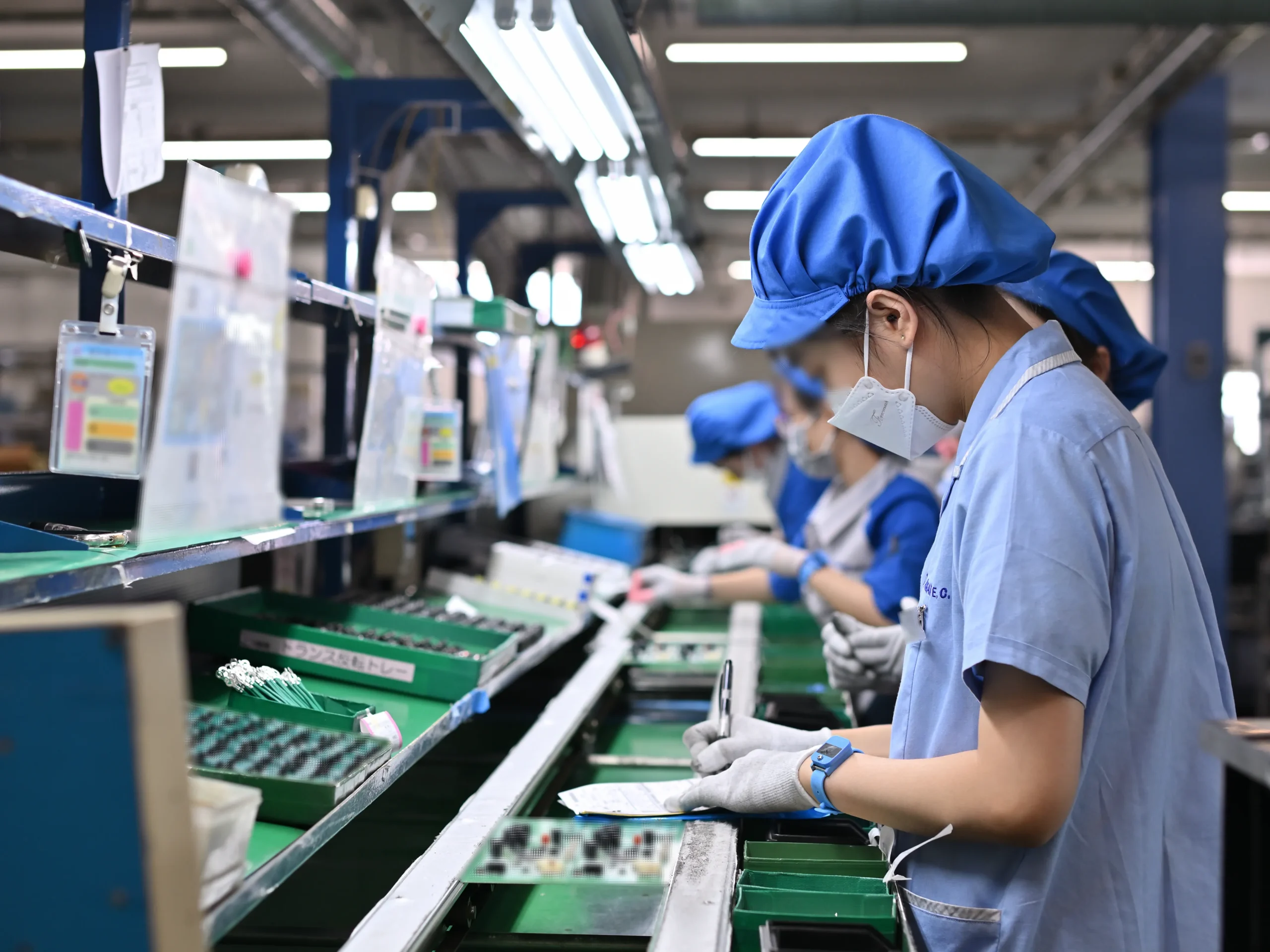 従業員が精密な作業を行う製造ラインの様子。監査の精度向上による検出件数の増加を、非効率や将来リスクの発見、さらなる品質向上への機会と前向きに捉える当社の姿勢を象徴する1枚