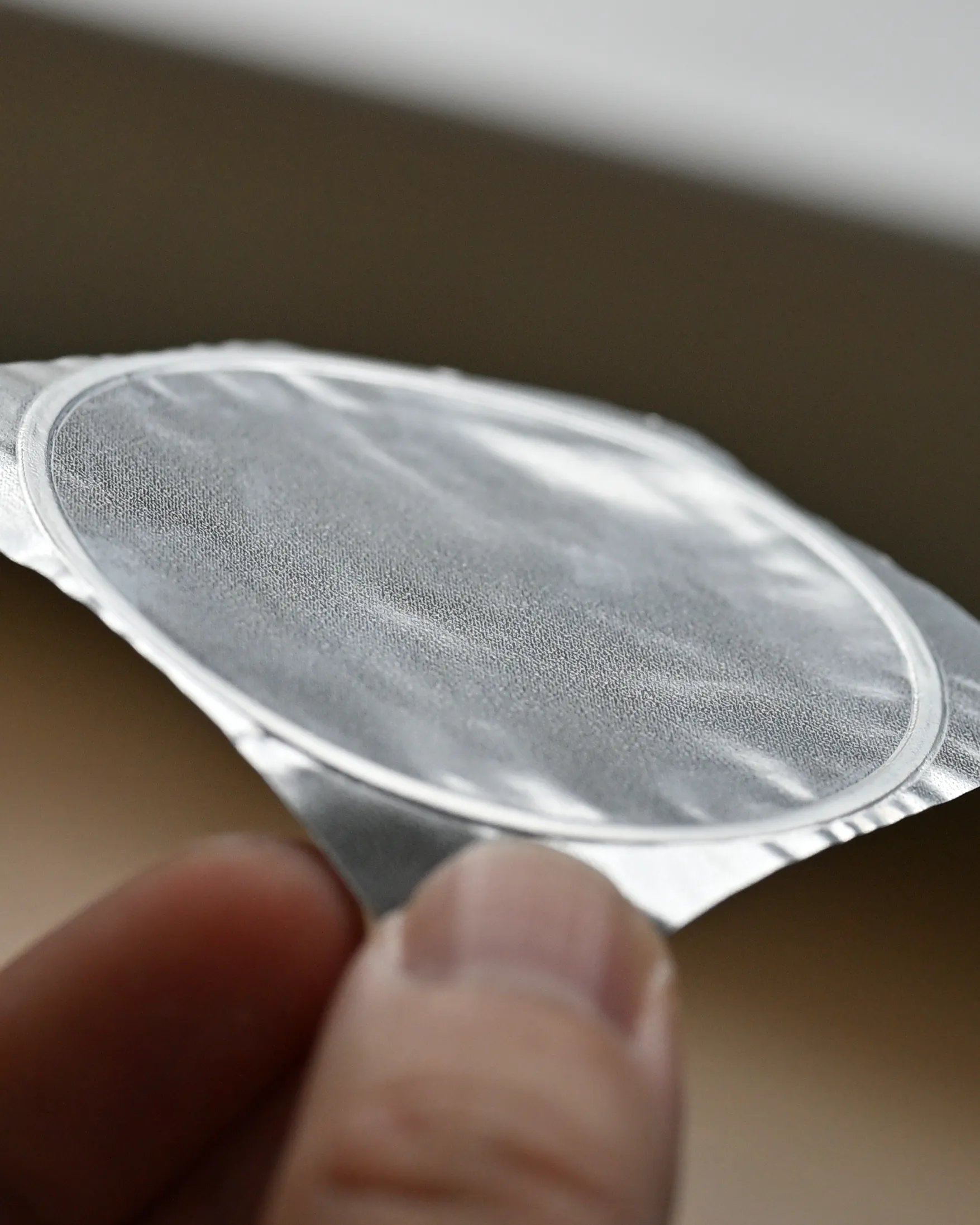 ヨーグルトが付着していないカップヨーグルトのフタ。フタの表面には、目視でも凹凸が見える。