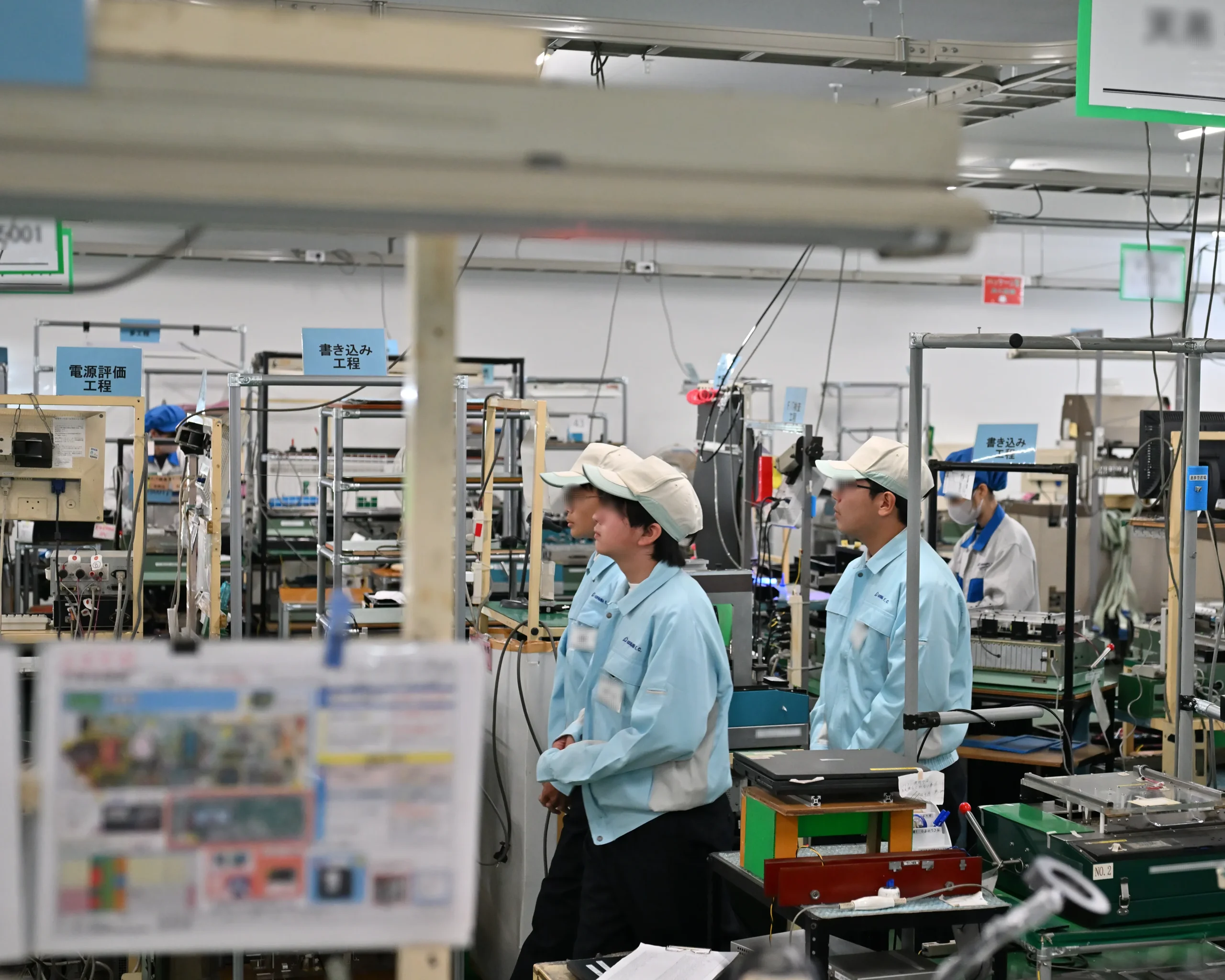 安曇川中学生がアドガワエレクトロニクスの製造現場で、基板実装風景や電装品の組立作業を見学する場面。