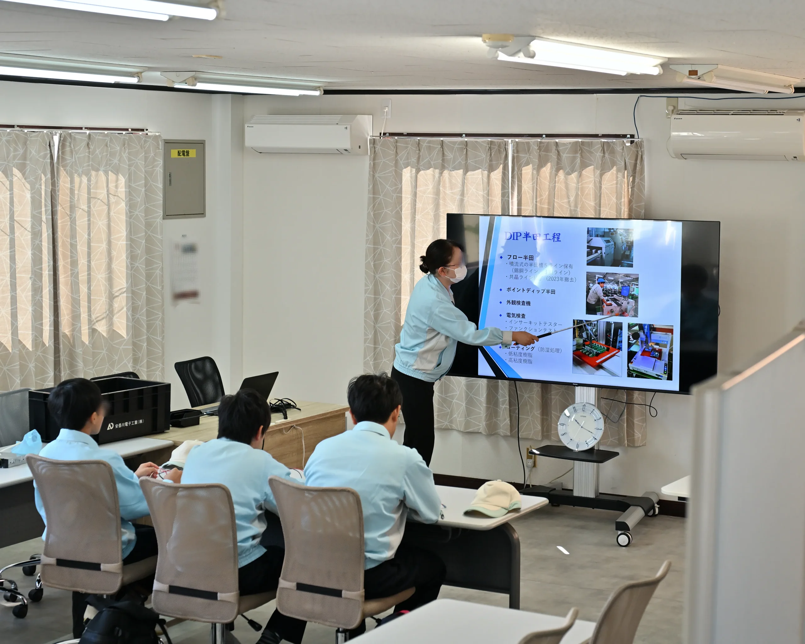 安曇川(あどがわ)中学生が職場体験で、練習用プリント基板と小型電子部品に触れて大きさや仕組みを確認する様子。