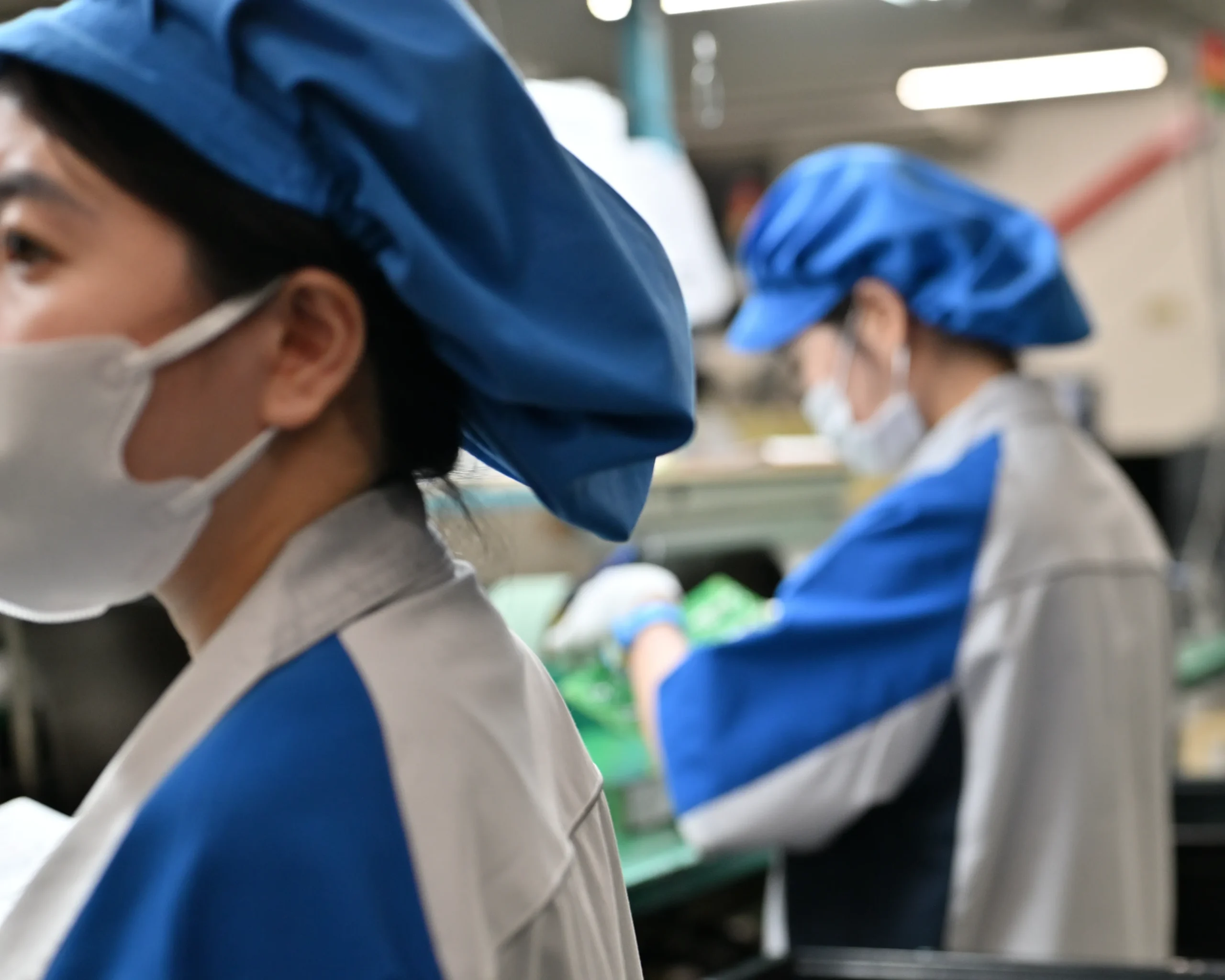 はんだ付け作業、検査工程に携わる従業員の様子。やりがいをもって働く従業員が職場に与えるポジティブな影響をイメージさせる。