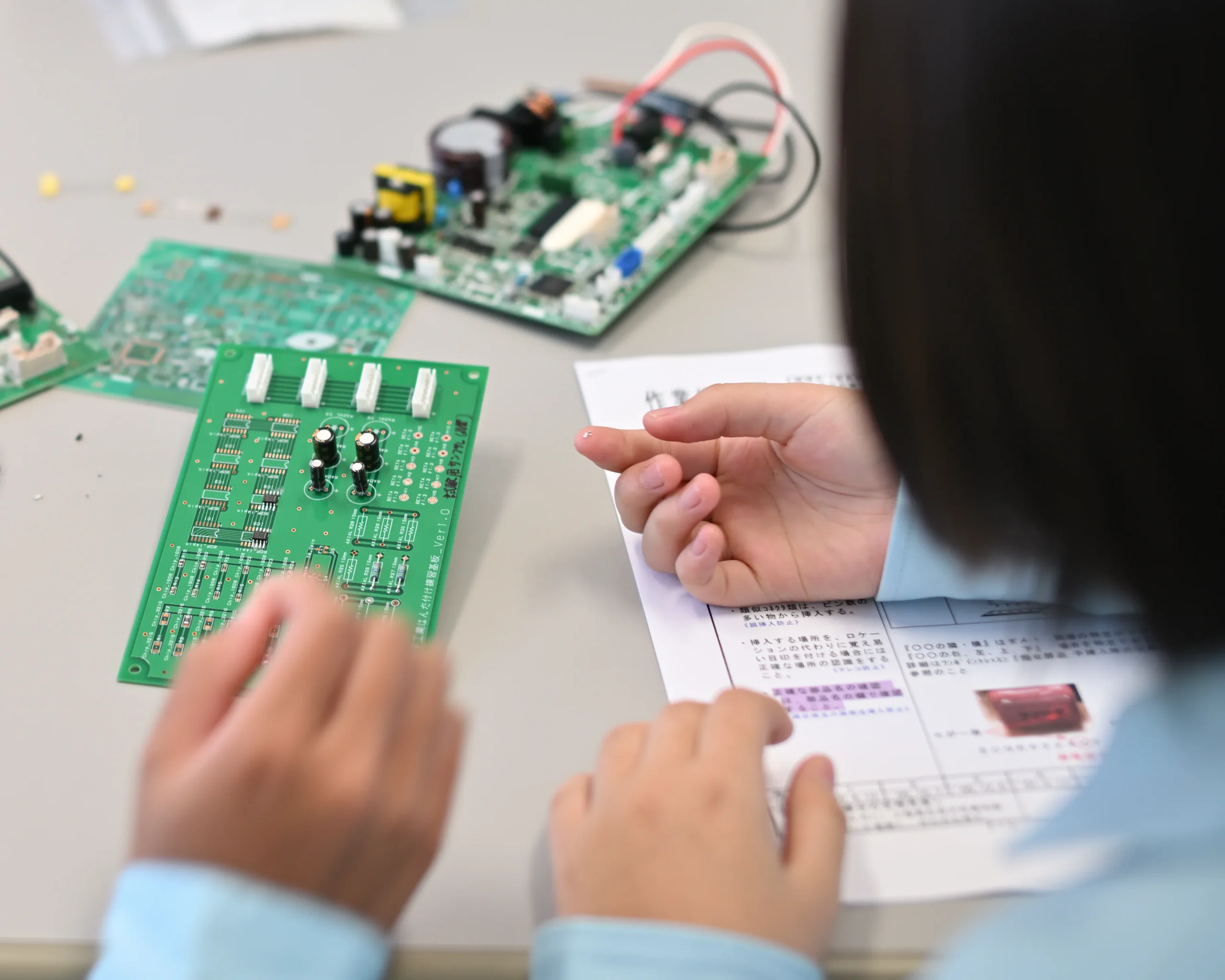 アドガワエレクトロニクスにて電気機械器具組立(基板実装)を体験する中学生の作業風景