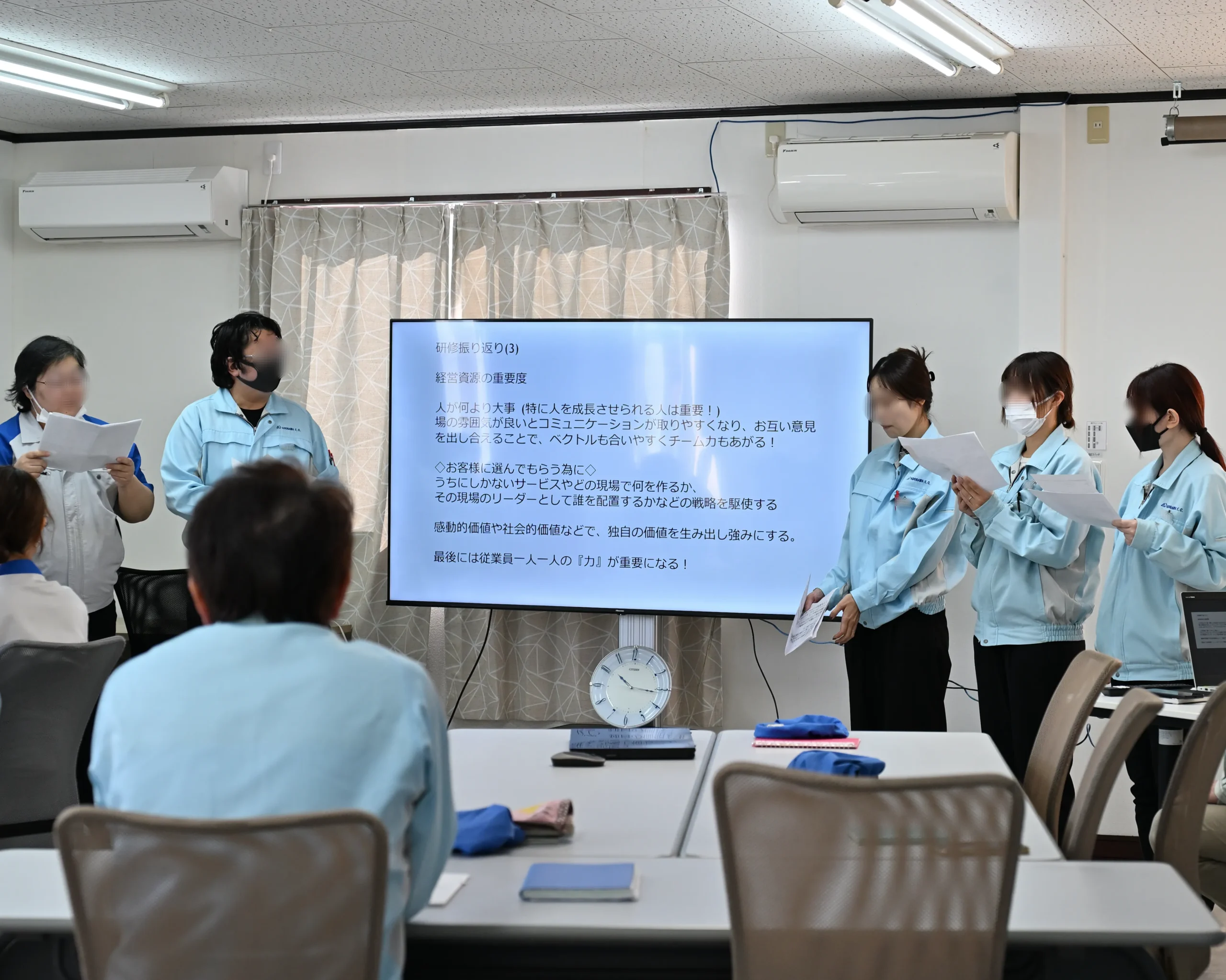 小集団改善活動(ボトムアップ活動)の発表前、真剣な表情で準備をする従業員